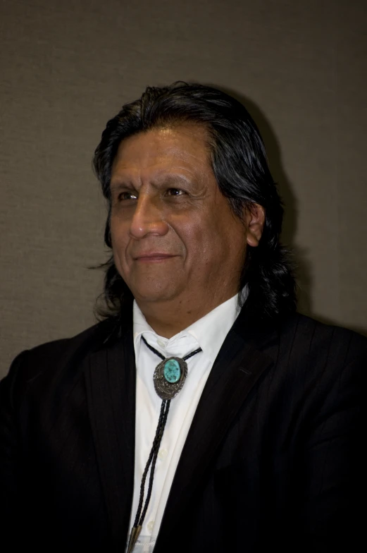 an older man with long hair in a suit and tie