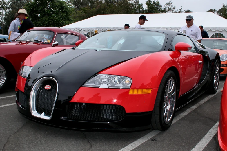 red and black bugatti in a parking lot with two men in suits