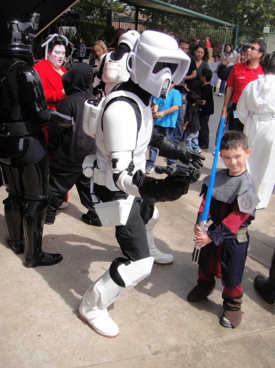 a boy in a costume is standing next to a robot