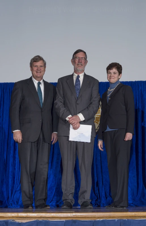 a man in suit and tie standing next to another man