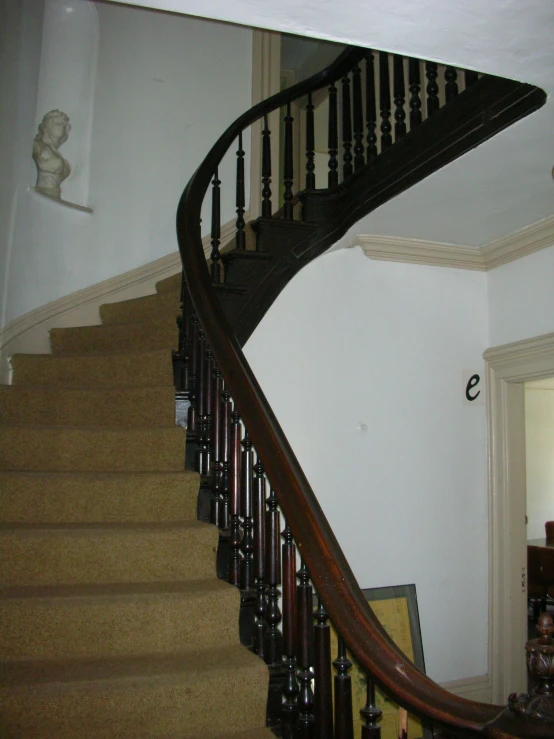 a spiral stair in an old house with wood floors