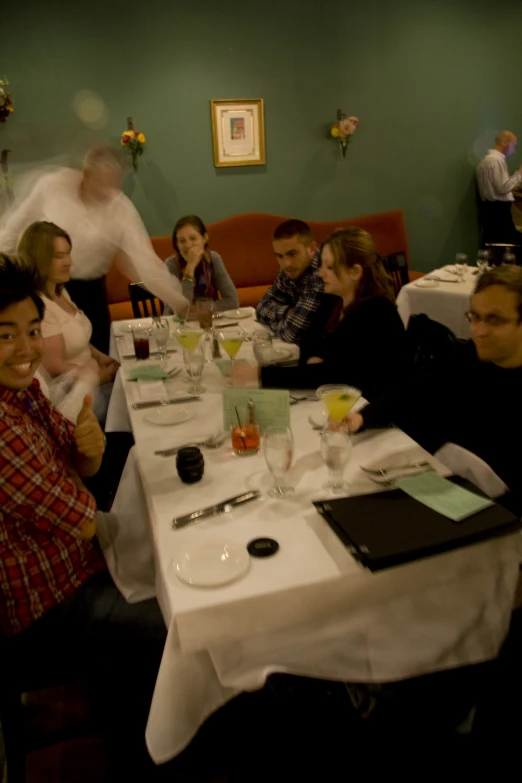 several people sit around tables with food in a restaurant