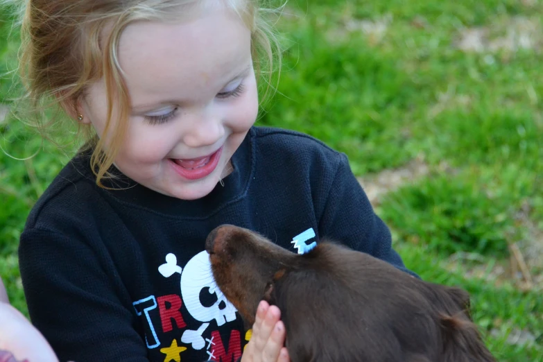a girl in a black shirt is holding her dog
