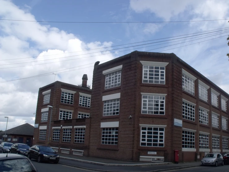 a brick building on the corner with lots of cars parked in front