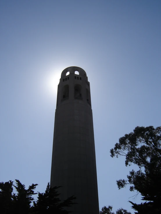 a clock tower with a sun in the background