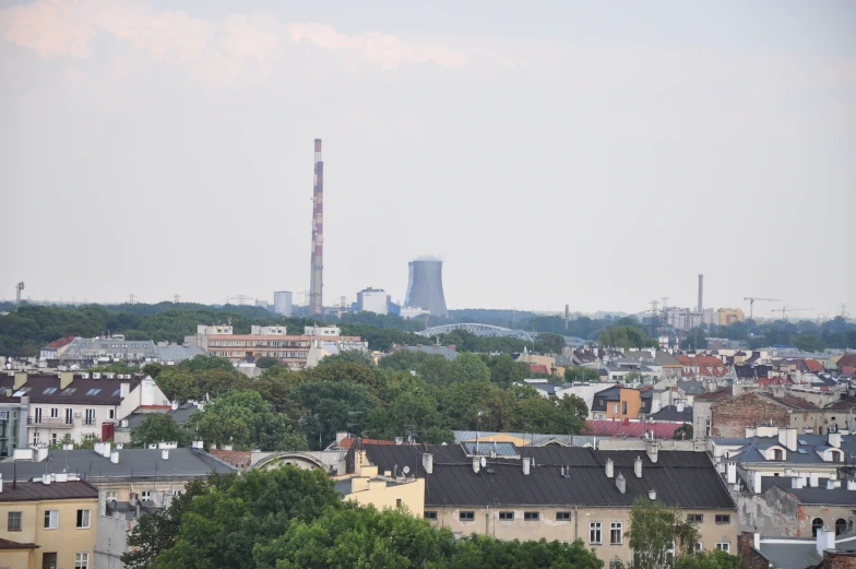 the tall smoke stack in the distance of the city