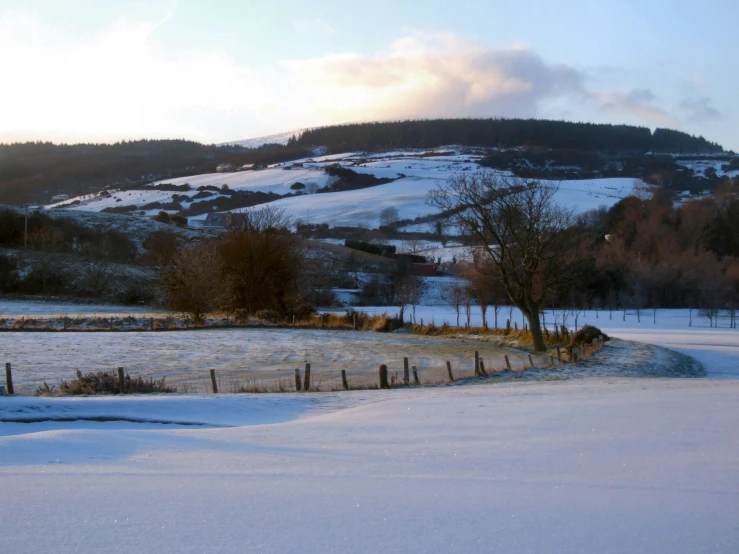 a snowy day with the sun setting on the hill