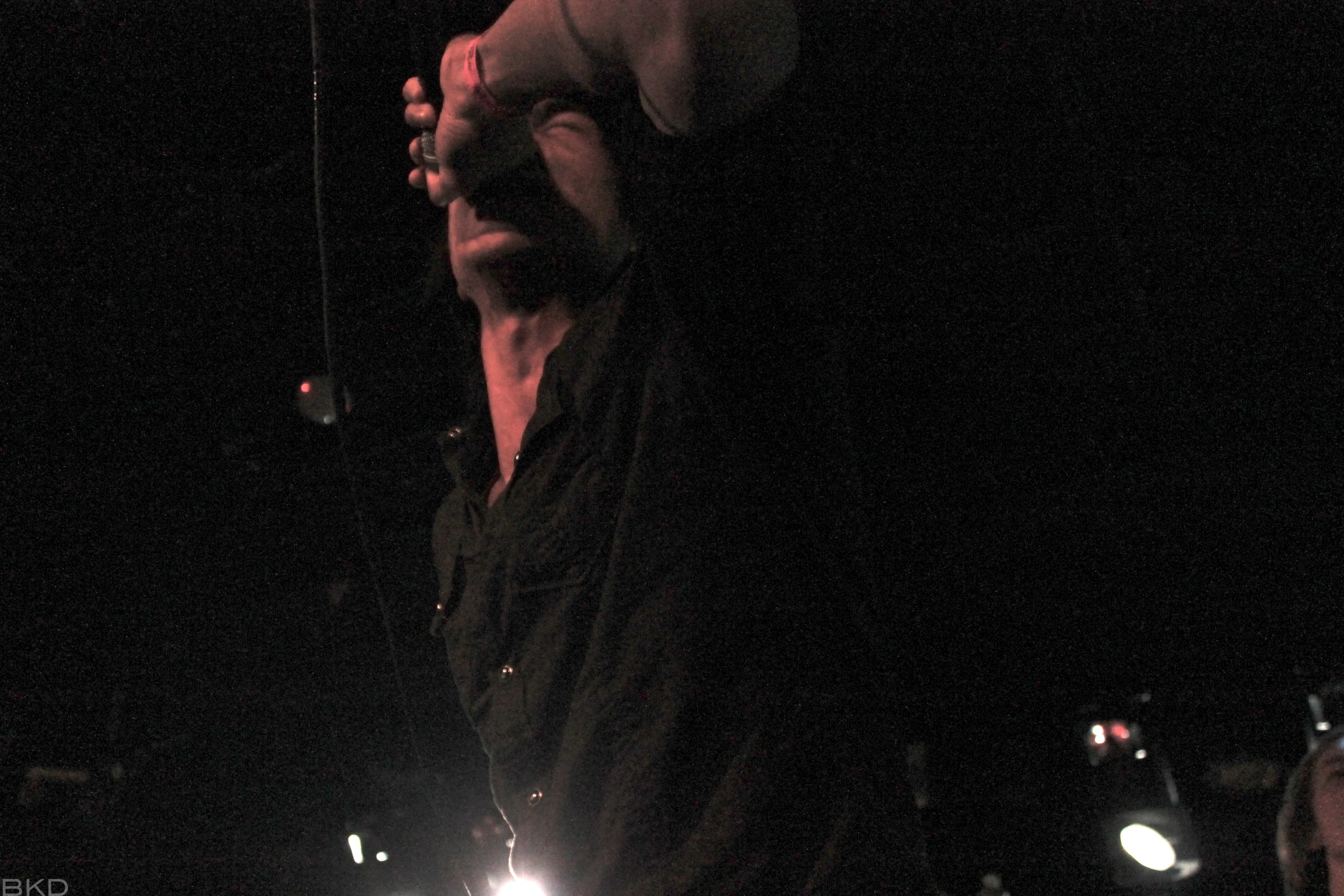 a young man standing in the dark doing an aerial trick