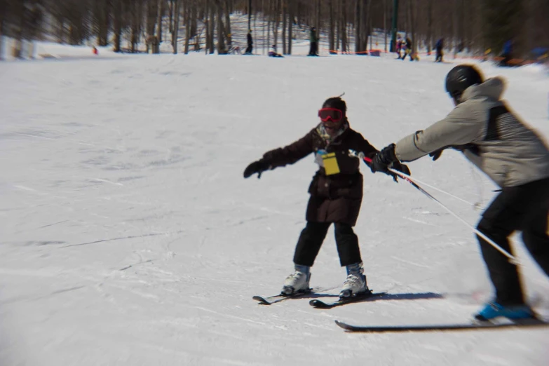 the people are skiing and one is holding hands