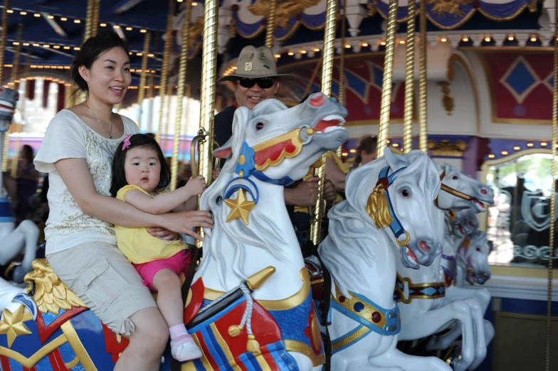 the  is on top of the carousel with her mom