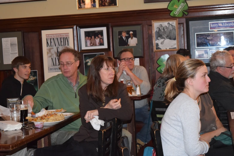 a group of people eating pizza and drinking beers