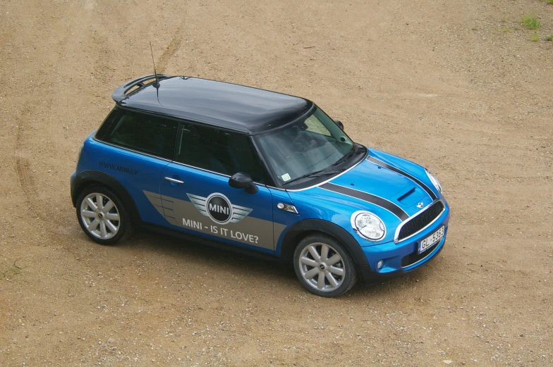 a small blue and black vehicle is parked in the dirt