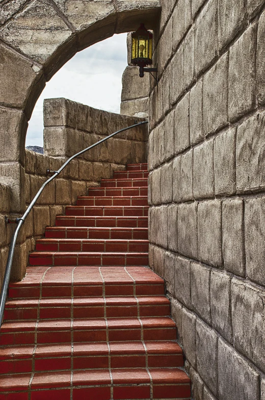 an arched stairway leads to a light at the end