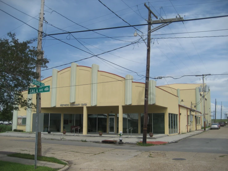 an empty street with a large building and two street signs on a pole