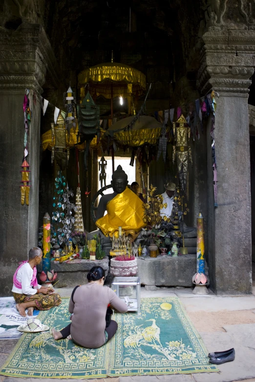 the man is working on the statue in front of the temple