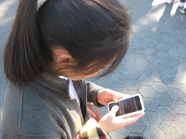 a girl looking down at her cell phone