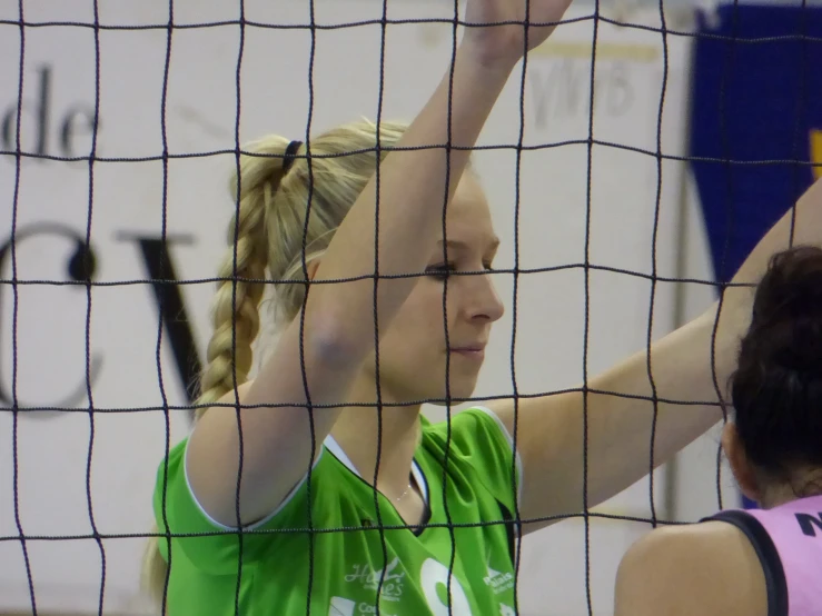 a girl in green is standing behind the net