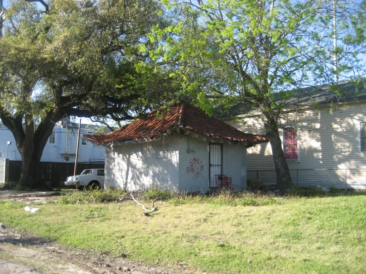 an old house with a rusted tin roof under a tree