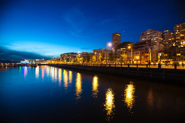 a city is lit up along a river at night