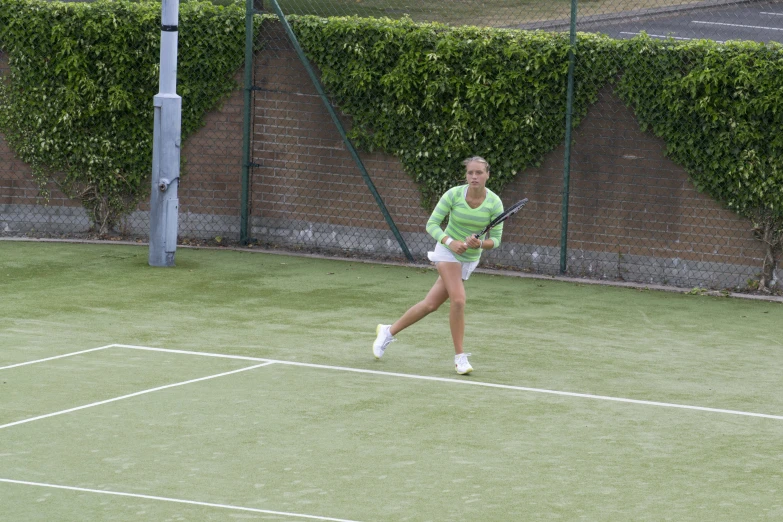 a woman is playing tennis on a court