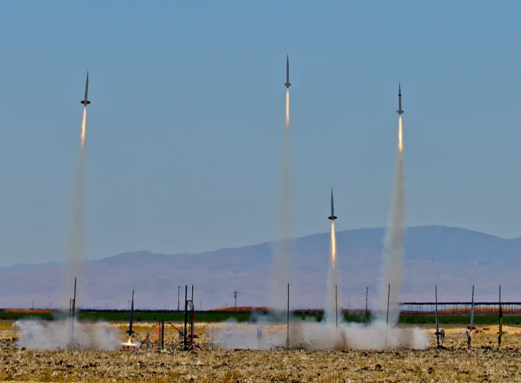 a small group of jets releasing rockets into the sky