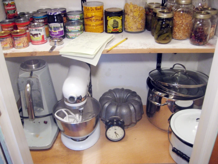 a kitchen pantry has lots of food and cooking implements on shelves