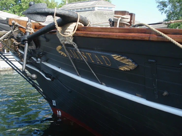 a large black boat with a lot of ropes