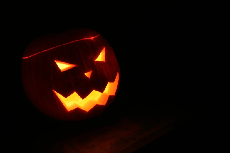 pumpkin carved as jack o lantern in the dark