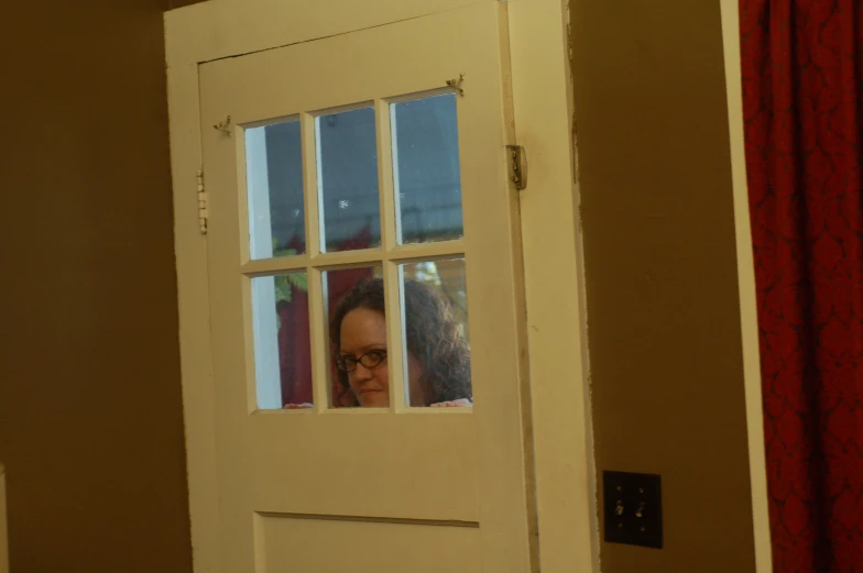 a woman looks through a window from inside