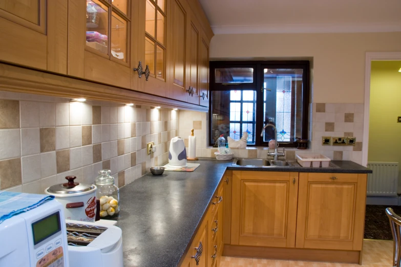 a very neat kitchen with black counters and tan tile