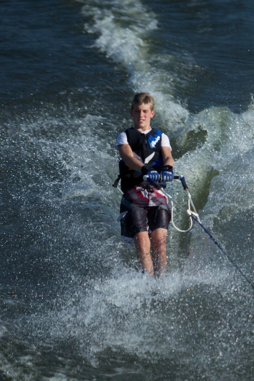 a young man on a wake board riding on a wave