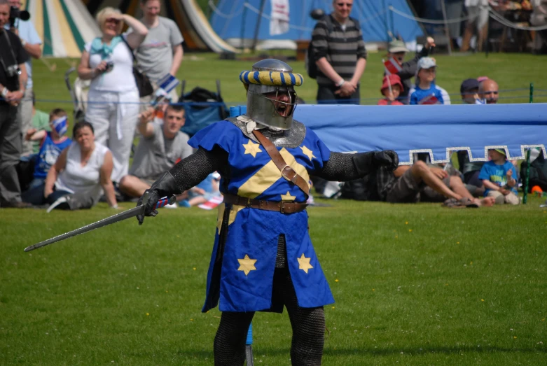 a man dressed in medieval armor standing in a field