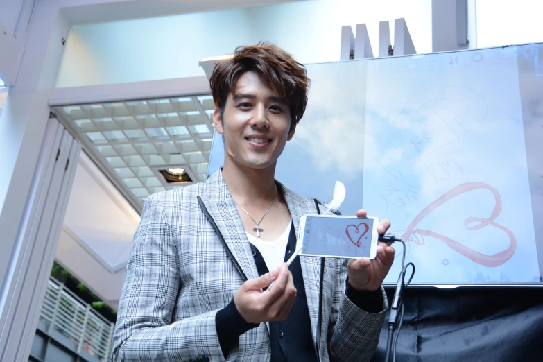 a man posing for the camera with a drawing in front of him