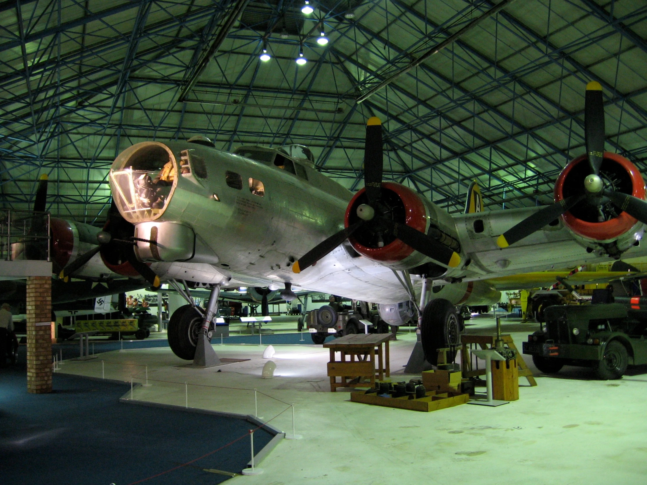 the airplane is in a hanger next to two trucks