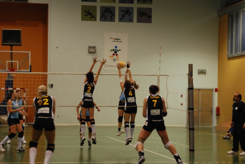 a group of people standing around each other with a volleyball