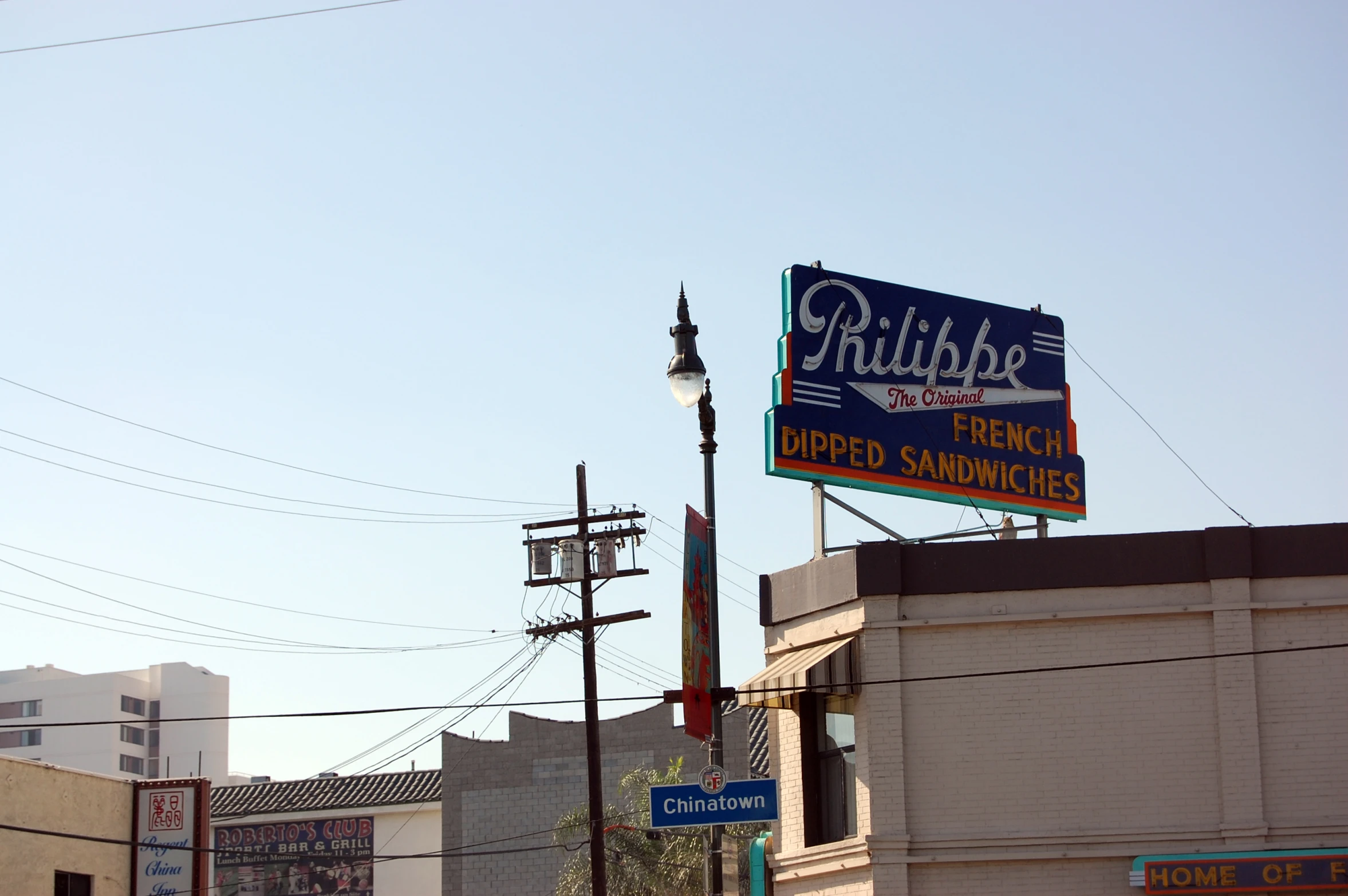 a sign on top of a building near a lamp pole