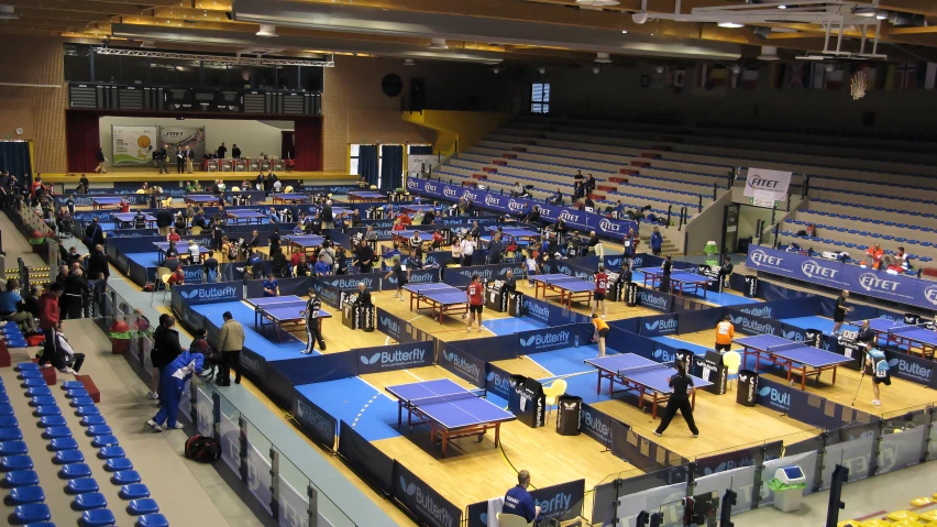 the large indoor table tennis center is crowded with people