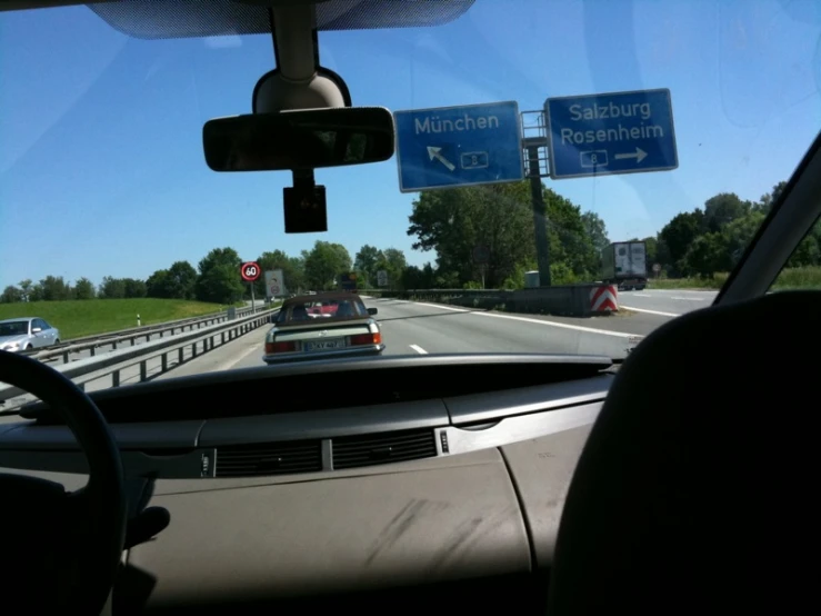 cars drive down the road, near signs in germany