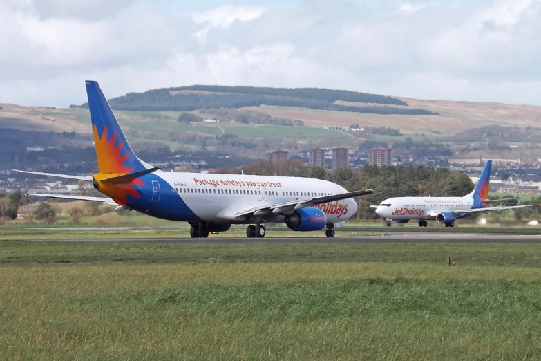 two large planes sitting on top of an airport tarmac