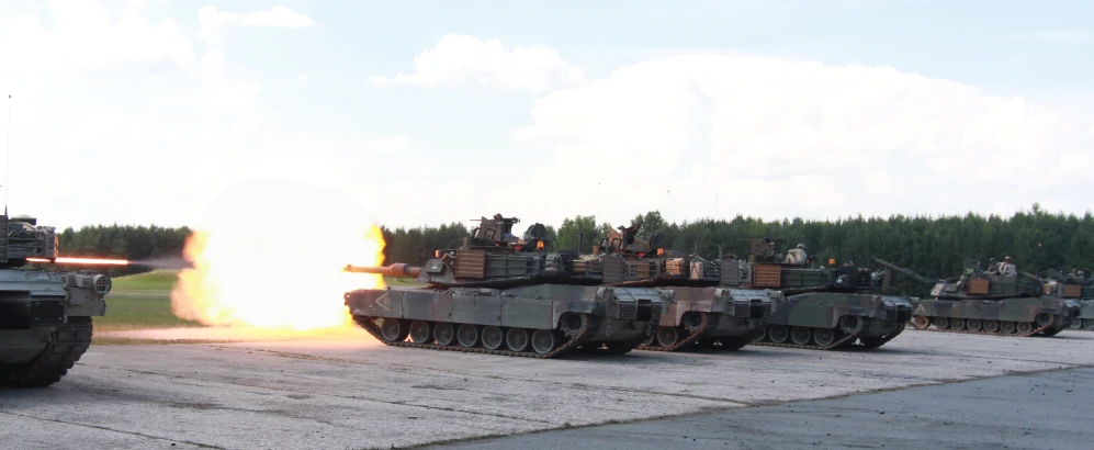 military vehicles with tanks passing each other near trees