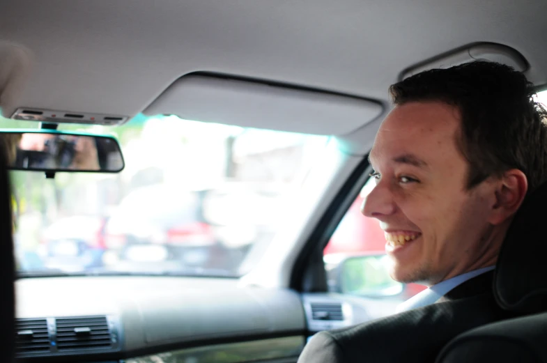 a man in a car is smiling at the camera