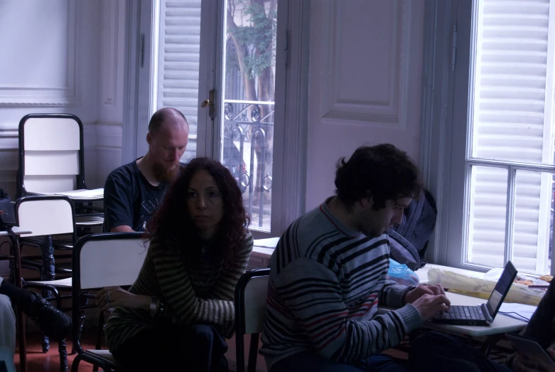 people sitting in a room with laptop computers