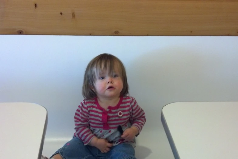 small girl sitting on top of a chair with her mouth open