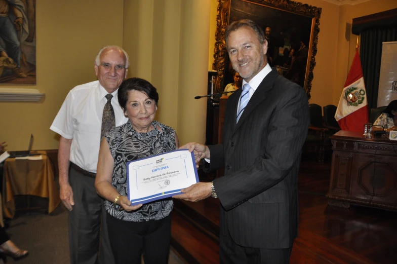 a man and a woman are holding an award plaque