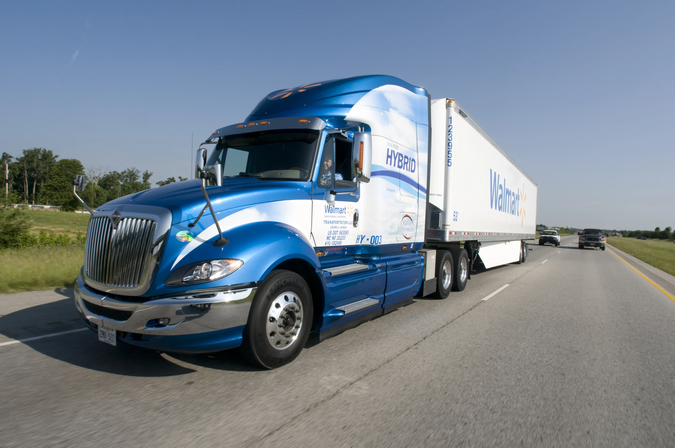 semi truck with white and blue cab driving on road