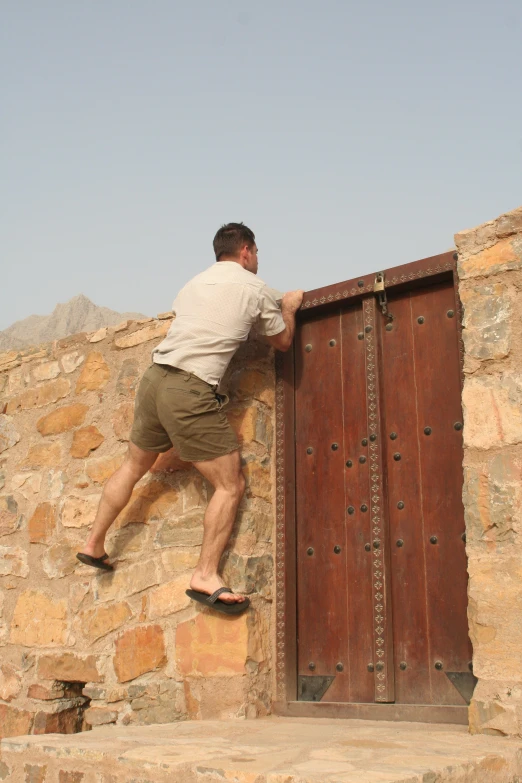 a man is climbing up a rock face