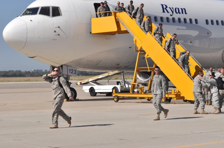 people are boarding a jet airplane while other people walk to it