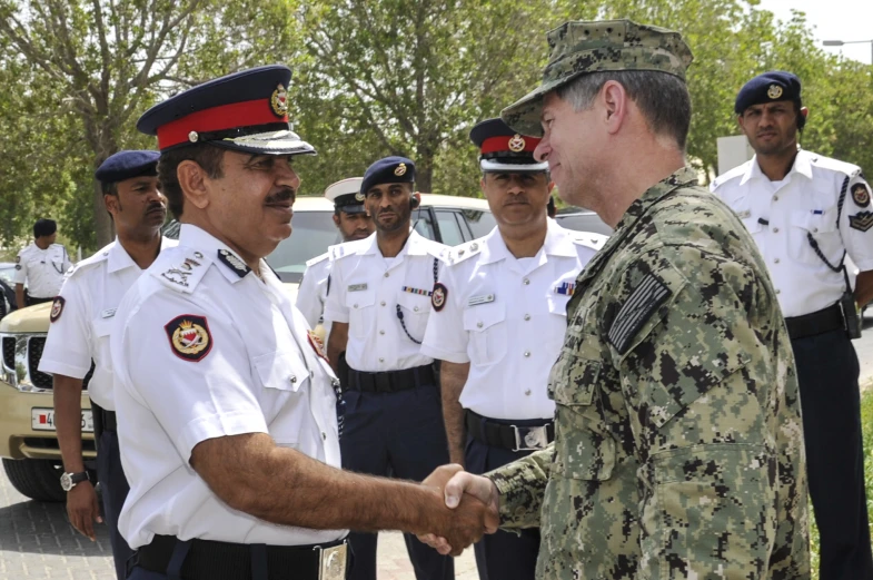 a man shakes hands with another man in a uniform
