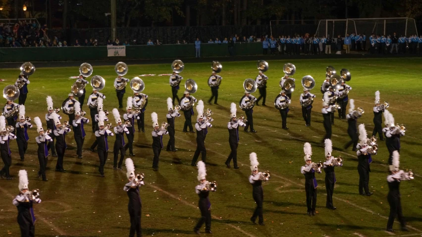 a large marching band is performing in a stadium