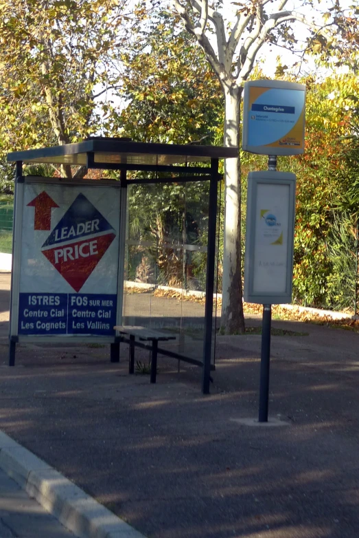 two billboard signs in front of a tree with sun light